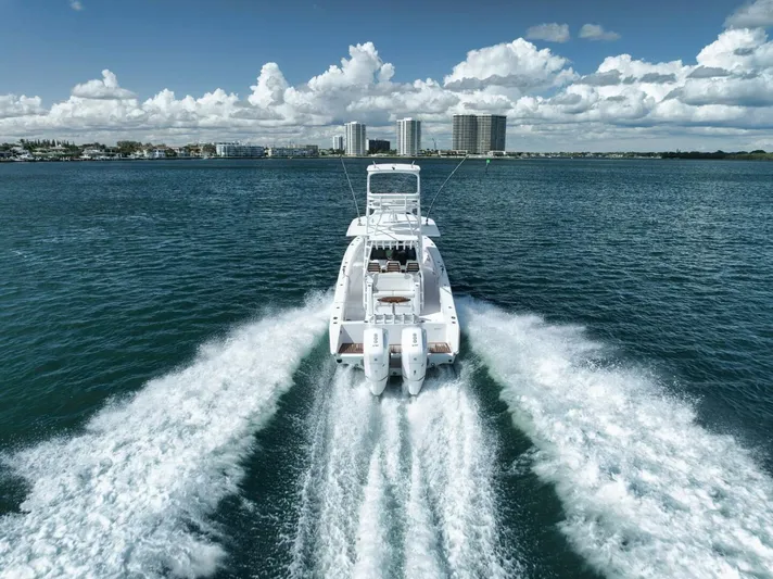  Yacht Photos Pics 2023 Jupiter 40 boat cruising on open water with city skyline in background.