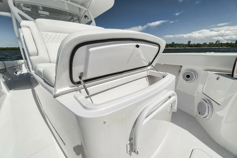  Yacht Photos Pics 2023 Jupiter 40 boat interior with open storage compartment, white seating, and ocean view.