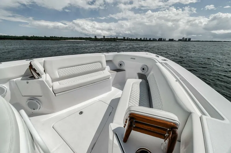  Yacht Photos Pics 2023 Jupiter 40 boat interior with white seating, on a calm sea under a cloudy sky.