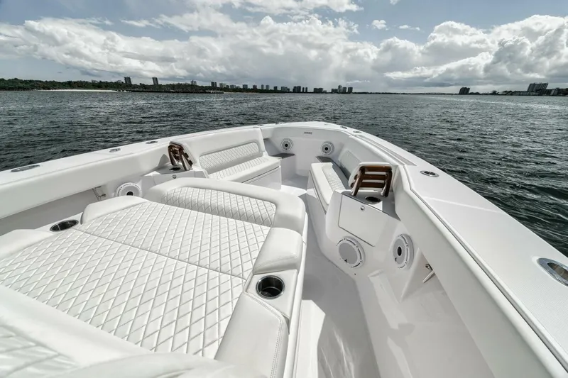  Yacht Photos Pics 2023 Jupiter 40 boat interior with white seating, on a calm sea under cloudy skies.