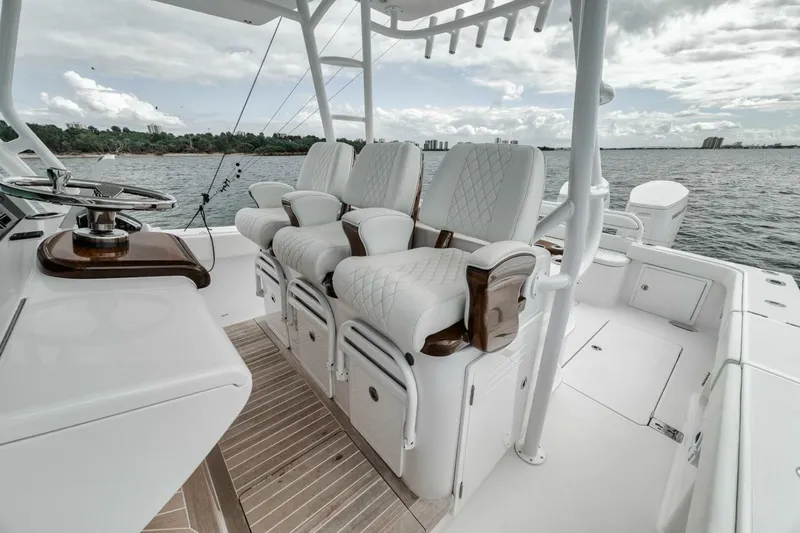  Yacht Photos Pics 2023 Jupiter 40 boat interior with luxurious seating and steering, overlooking calm waters.