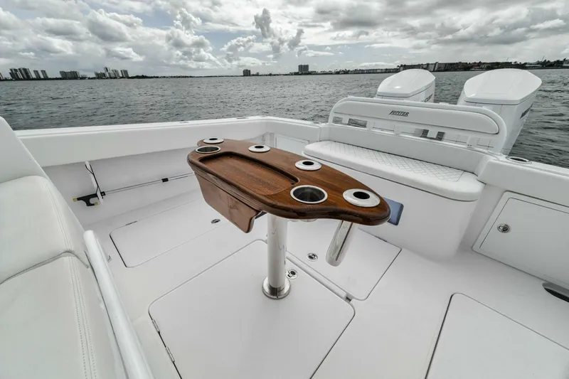  Yacht Photos Pics Luxury Jupiter 40 boat deck with wooden table, cup holders, and ocean view, 2023 model.