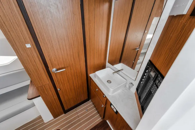  Yacht Photos Pics Modern bathroom interior in 2023 Jupiter 40 boat with wood paneling and sleek fixtures.