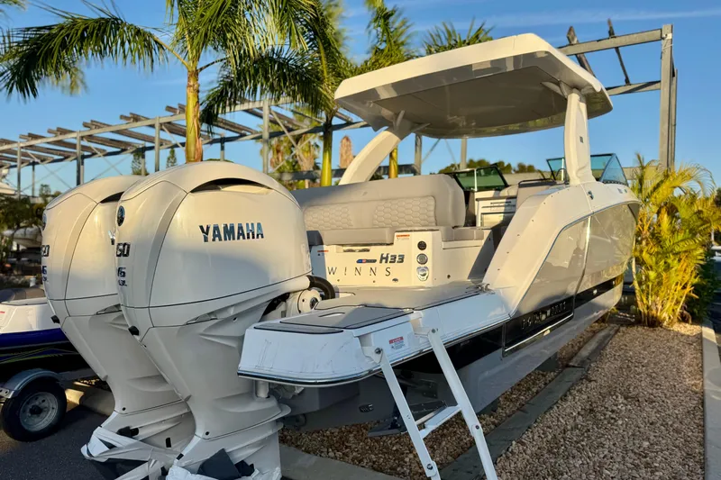 Yacht Photos Pics 2026 Four Winns H33 OB boat with Yamaha engines, docked under palm trees.