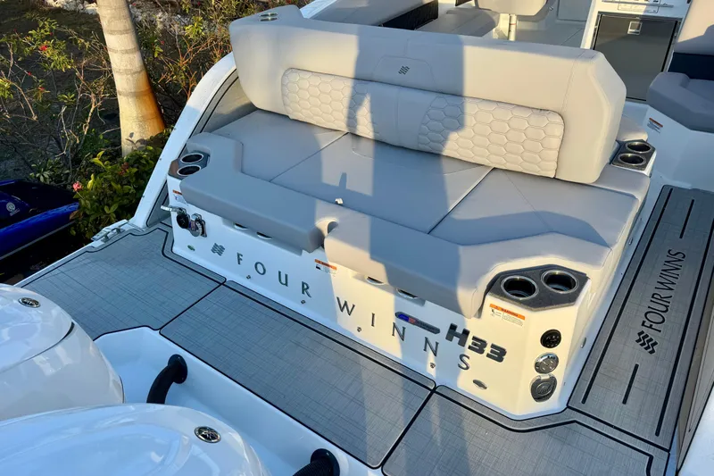  Yacht Photos Pics 2026 Four Winns H33 OB boat with cushioned seating and cup holders on deck.