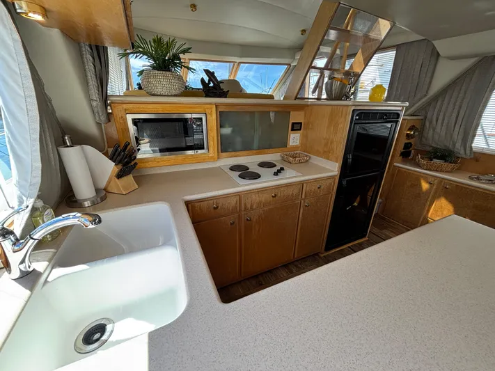 Orca Belle Yacht Photos Pics Luxurious kitchen interior of 2000 Navigator 5300 yacht with modern appliances and wooden cabinetry.