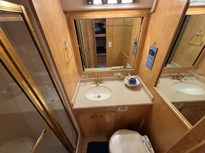 Orca Belle Yacht Photos Pics Luxurious bathroom in 2000 Navigator 5300 yacht with wood accents and gold fixtures.