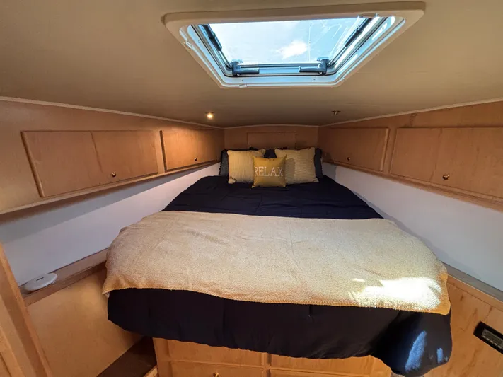 Orca Belle Yacht Photos Pics Cozy bedroom in 2000 Navigator 5300 yacht with skylight and wooden cabinets.