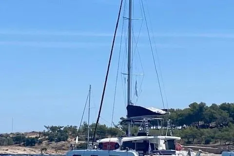 Seis Al Mar Yacht Photos Pics 2018 Seawind 1260 catamaran anchored near a scenic coastline.