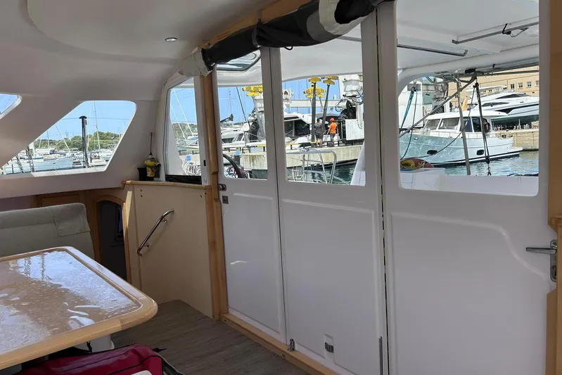 Seis Al Mar Yacht Photos Pics Interior view of 2018 Seawind 1260 catamaran with marina in background.