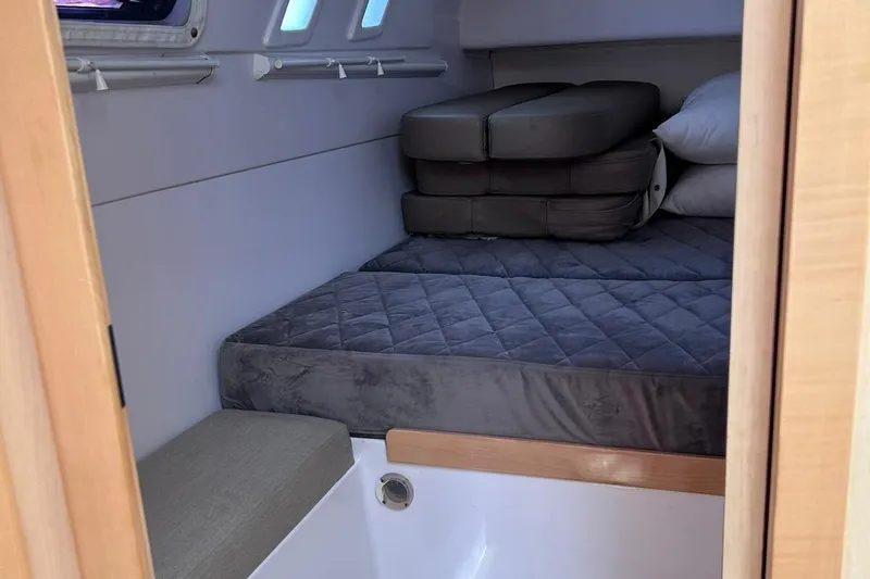 Seis Al Mar Yacht Photos Pics Cozy cabin interior of 2018 Seawind 1260 catamaran with gray bedding and cushions.