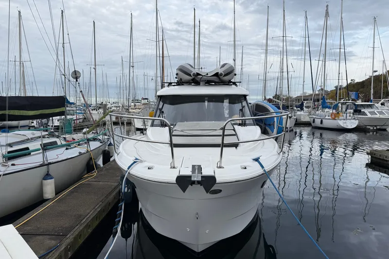  Yacht Photos Pics 2019 Jeanneau NC 895 docked at a marina, surrounded by sailboats.