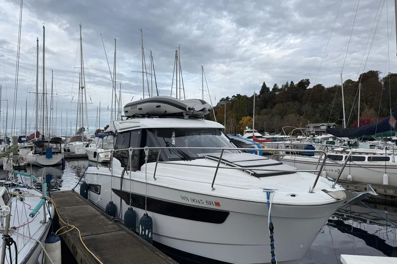  Yacht Photos Pics 2019 Jeanneau NC 895 docked at a marina with sailboats and cloudy sky.