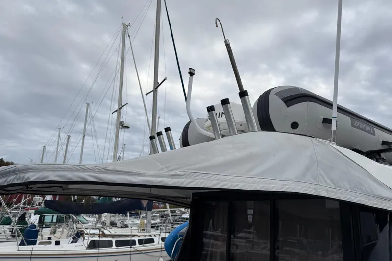  Yacht Photos Pics 2019 Jeanneau NC 895 boat with dinghy on top, docked at marina under cloudy sky.