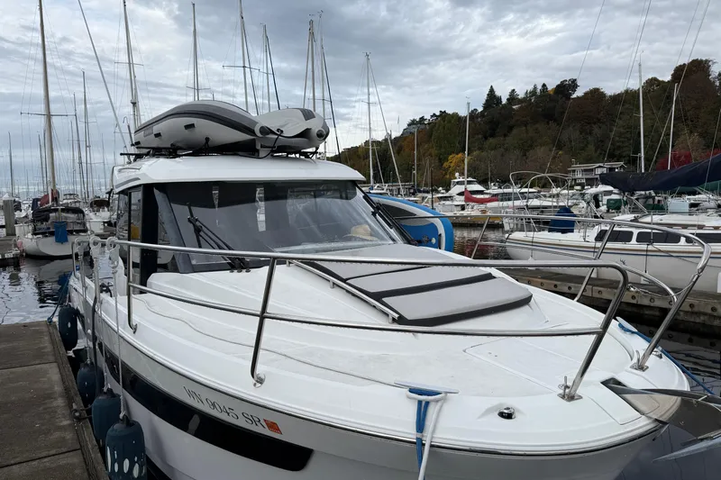  Yacht Photos Pics 2019 Jeanneau NC 895 docked at a marina with sailboats in the background.