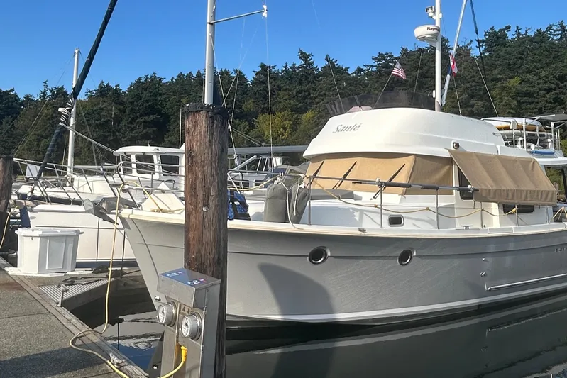 Sante Yacht Photos Pics 2013 Beneteau Swift Trawler 34 Fly docked at marina, surrounded by trees.