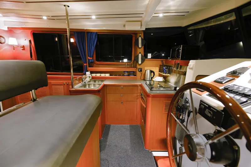Sante Yacht Photos Pics Interior of 2013 Beneteau Swift Trawler 34 Fly, featuring helm and kitchen area.