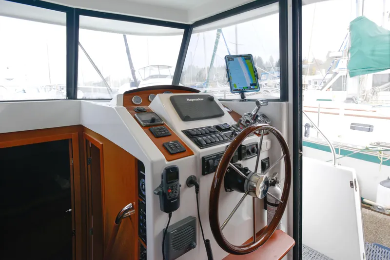 Sante Yacht Photos Pics Helm of 2013 Beneteau Swift Trawler 34 Fly with navigation equipment and wooden steering wheel.