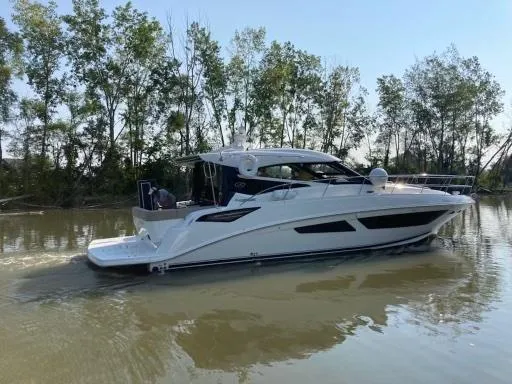  Yacht Photos Pics 2016 Sea Ray 470 Sundancer cruising on a calm river, surrounded by trees.