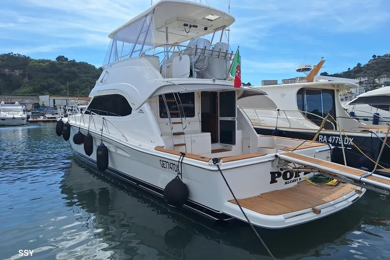 Pope Yacht Photos Pics 2003 Riviera Marine Riviera 51 yacht docked in a marina, featuring sleek design and spacious deck.