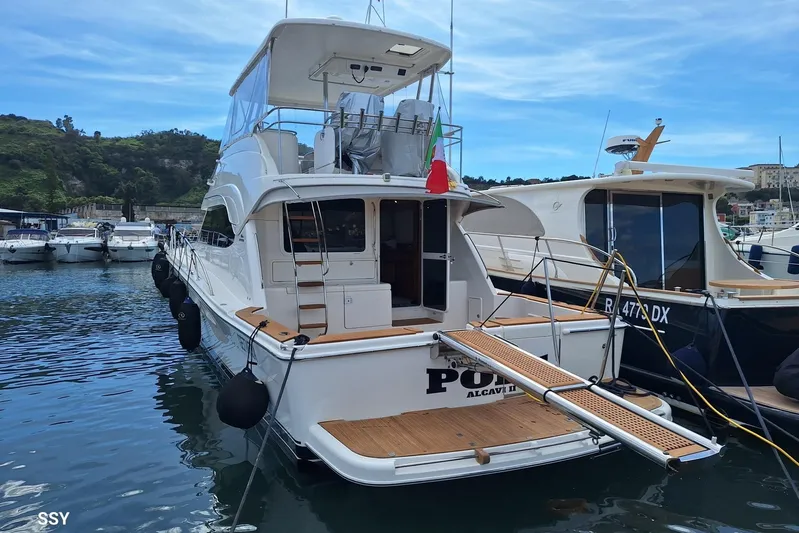 Pope Yacht Photos Pics 2003 Riviera Marine Riviera 51 yacht docked in a marina, featuring a spacious deck.