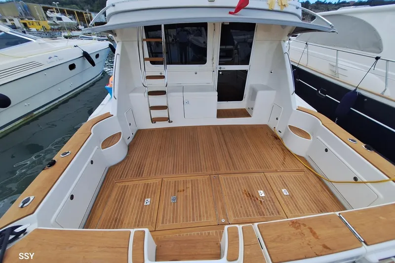 Pope Yacht Photos Pics 2003 Riviera Marine Riviera 51 yacht with spacious teak deck and ladder, docked at marina.