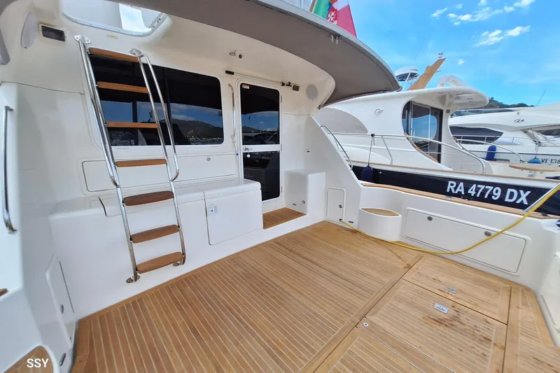 Pope Yacht Photos Pics 2003 Riviera Marine Riviera 51 yacht deck with wooden flooring and ladder.