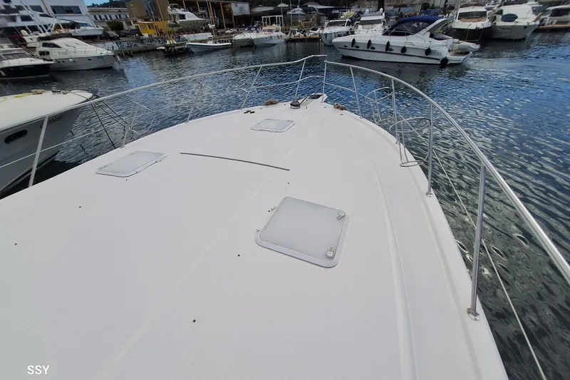 Pope Yacht Photos Pics 2003 Riviera Marine Riviera 51 yacht docked in a marina, showcasing its spacious deck.