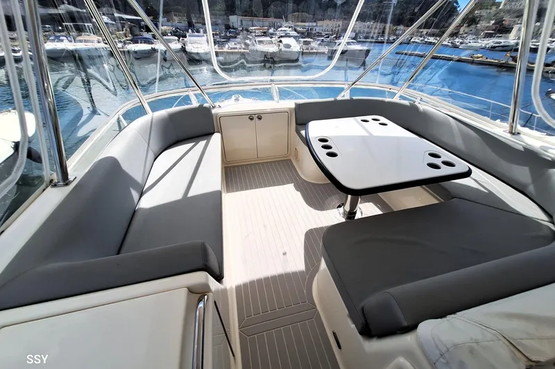 Pope Yacht Photos Pics 2003 Riviera Marine Riviera 51 yacht interior with seating and table, docked at marina.