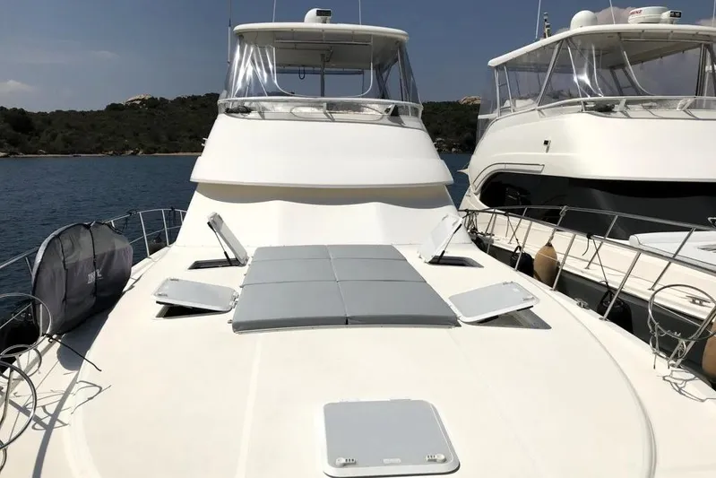 Pope Yacht Photos Pics 2003 Riviera Marine Riviera 51 yacht with sunbathing deck, docked beside another boat.