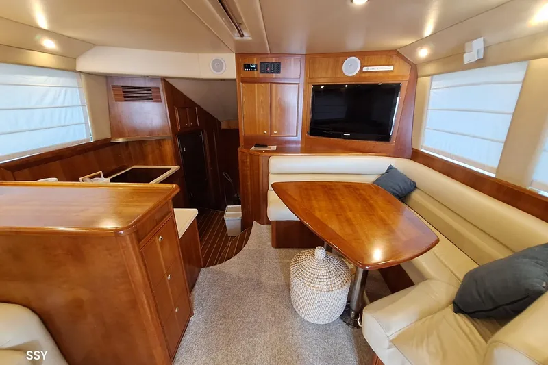 Pope Yacht Photos Pics Luxurious 2003 Riviera 51 yacht interior with wood finishes and cozy seating area.