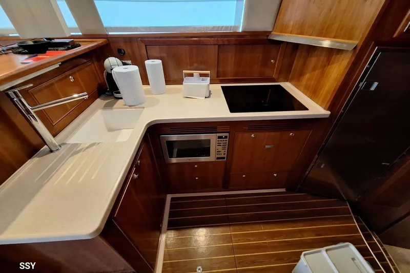 Pope Yacht Photos Pics Luxurious 2003 Riviera 51 yacht kitchen with modern appliances and elegant wood finish.