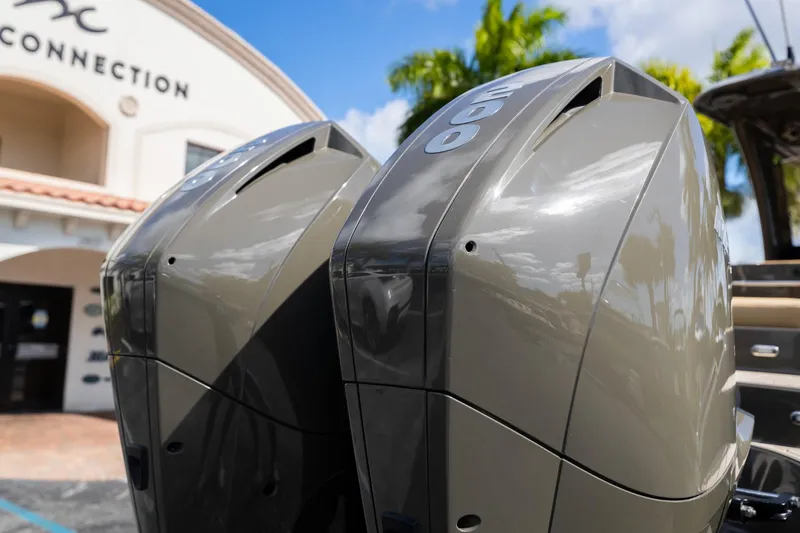 Airship 310 Yacht Photos Pics Twin outboard motors on a 2023 Airship 310 boat, with a building in the background.