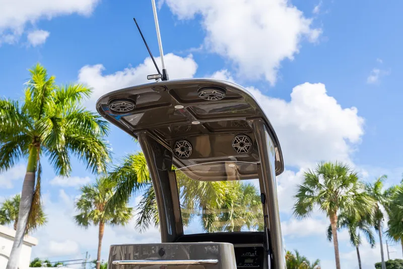 Airship 310 Yacht Photos Pics 2023 Airship 310 boat canopy with speakers, set against a tropical palm tree backdrop.