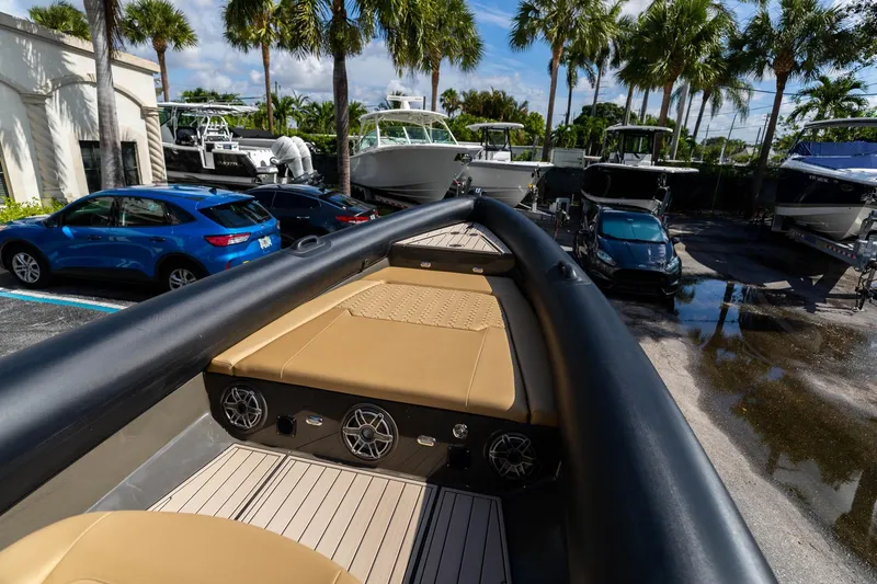 Airship 310 Yacht Photos Pics 2023 Airship 310 boat with tan seating, parked near cars and palm trees.