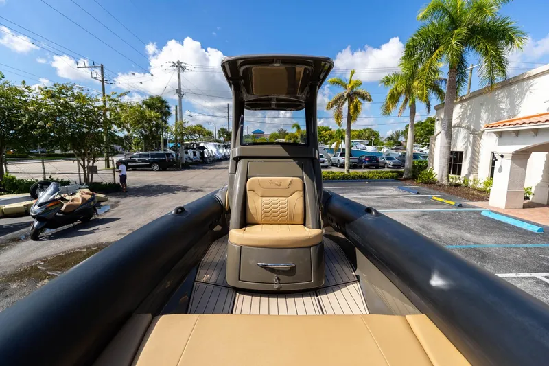 Airship 310 Yacht Photos Pics 2023 Airship 310 boat with tan seating, parked in a sunny lot with palm trees.