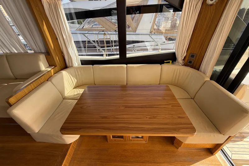  Yacht Photos Pics Luxurious interior of 2015 Absolute 56 FLY yacht with elegant wood table and cream seating.