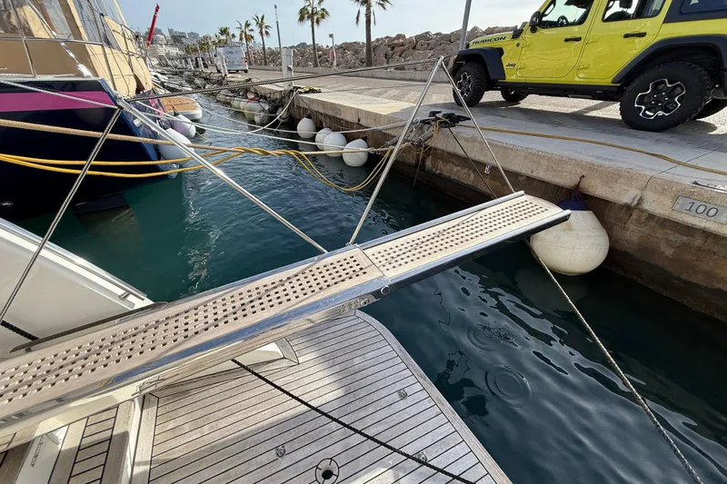  Yacht Photos Pics Docked Absolute 56 FLY yacht with gangway, near a yellow Jeep Rubicon, 2015 model.