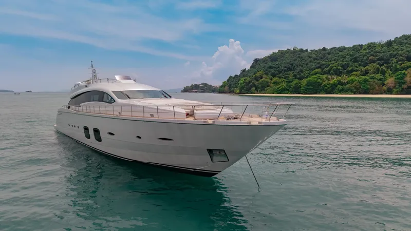 Le Caprice IV Yacht Photos Pics Luxurious 2011 Pershing 108 yacht cruising near a lush, green island.