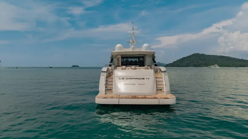 Le Caprice IV Yacht Photos Pics Luxury Pershing 108 yacht on serene waters, 2011 model, with scenic island backdrop.