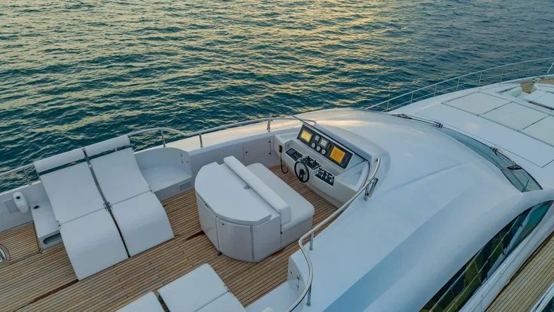 Le Caprice IV Yacht Photos Pics Luxurious 2011 Pershing 108 yacht deck with sun loungers and helm, overlooking serene ocean waters.