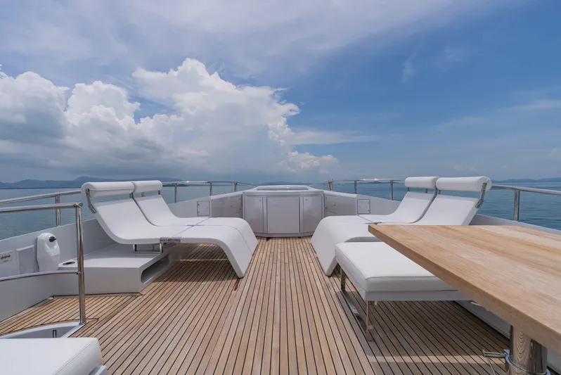 Le Caprice IV Yacht Photos Pics Luxurious deck of 2011 Pershing 108 yacht with white loungers and wooden flooring.