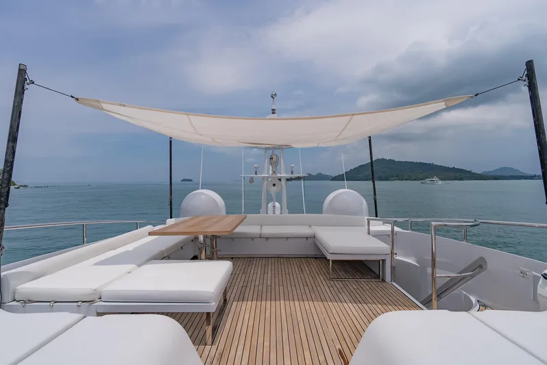 Le Caprice IV Yacht Photos Pics Luxurious 2011 Pershing 108 yacht deck with seating, table, and canopy, overlooking serene ocean view.