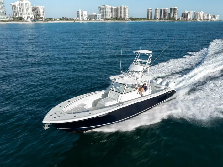  Yacht Photos Pics 2016 Yellowfin 42 boat cruising on ocean near city skyline.