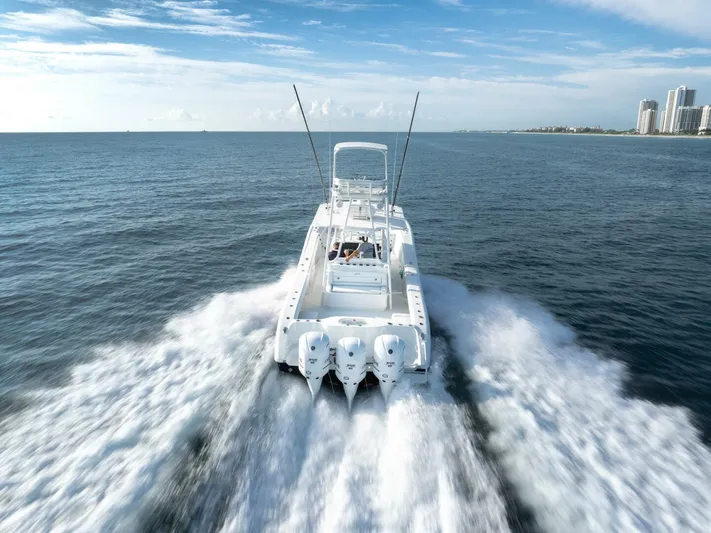  Yacht Photos Pics 2016 Yellowfin 42 boat cruising on open ocean with city skyline in background.