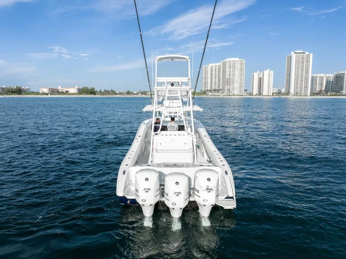  Yacht Photos Pics 2016 Yellowfin 42 boat with triple engines on open water, city skyline in background.
