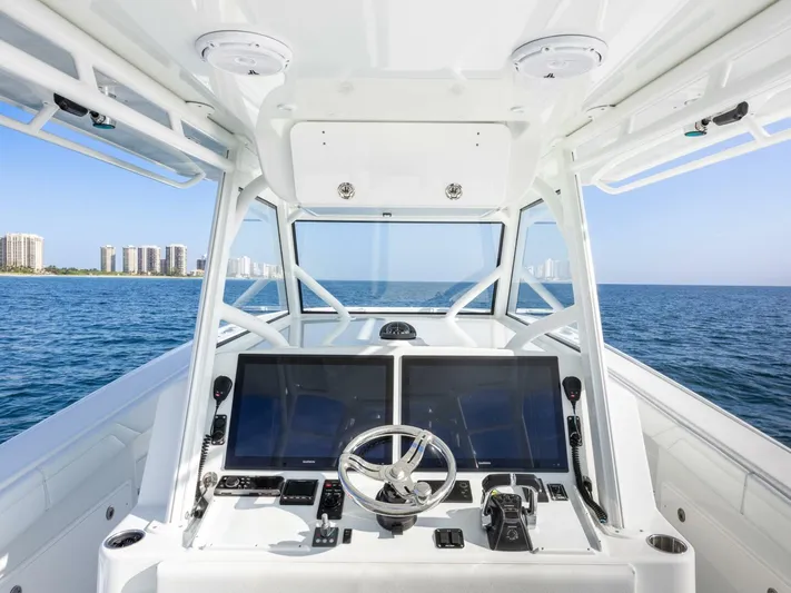  Yacht Photos Pics 2016 Yellowfin 42 boat cockpit with dual screens, steering wheel, and ocean view.