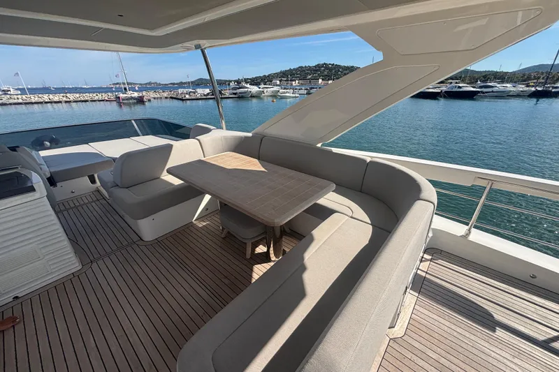  Yacht Photos Pics Luxurious seating area on 2023 Absolute 60 Fly yacht, overlooking serene marina waters.