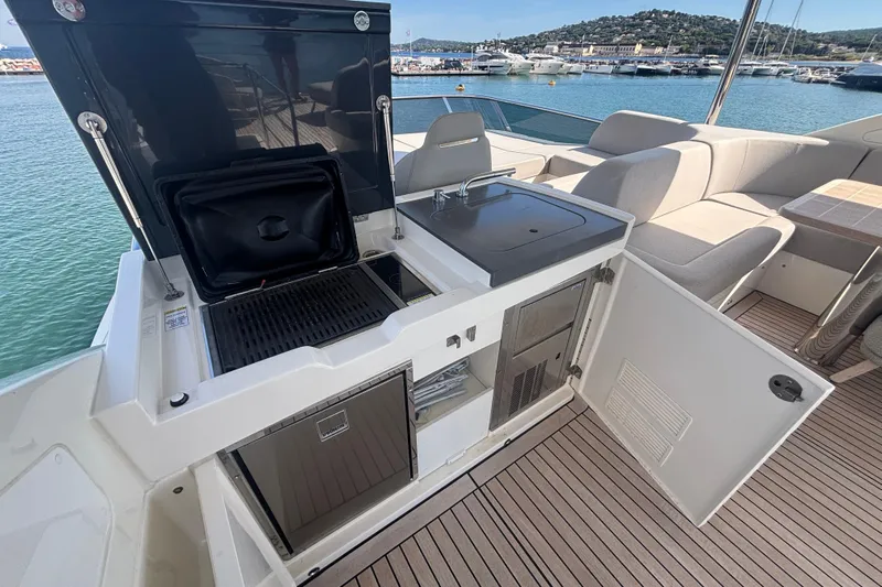  Yacht Photos Pics Outdoor kitchen on 2023 Absolute 60 Fly yacht with grill, sink, and seating area.
