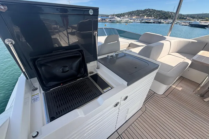  Yacht Photos Pics Outdoor kitchen on 2023 Absolute 60 Fly yacht with grill and sink, docked at marina.